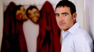 Álex Pina con los monos rojos de los atracadores colgados detrás